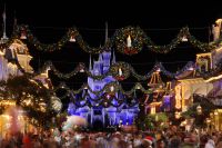 christmas decorations strung across street and disney castle in icicle lights