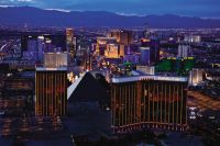 las vegas hotels and casinos on bright neon strip with purple mountains behind
