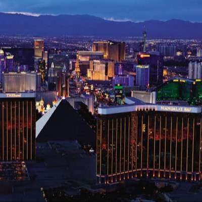 las vegas hotels and casinos on bright neon strip with purple mountains behind