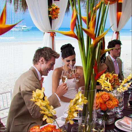 wedding head table with bright orange and green cut flowers