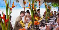 wedding head table with bright orange and green cut flowers